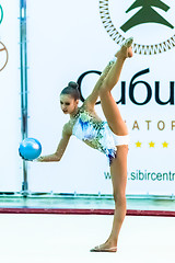 Image showing Young beautiful girl shows exercise with ball