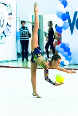 Image showing Young beautiful girl shows exercise with ball