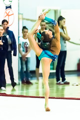 Image showing Young beautiful girl shows exercise with ball