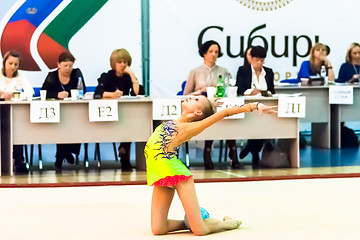 Image showing Young girl shows exercise with ball to judges