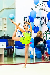 Image showing Young beautiful girl shows exercise with ball