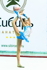 Image showing Young beautiful girl shows exercise with ball