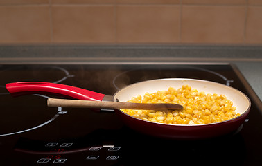 Image showing cooking sweet conn with wooden spoon