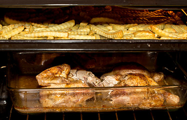 Image showing fresh chicken and french fries in oven