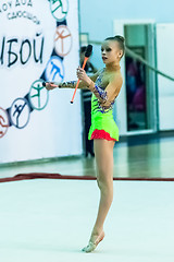 Image showing Young beautiful girl shows exercise with maces