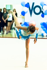 Image showing Young beautiful girl shows exercise with ball