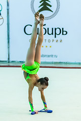 Image showing Young beautiful girl shows exercise with maces