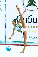 Image showing Young beautiful girl shows exercise with ball