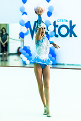 Image showing Young beautiful girl shows exercise with ball