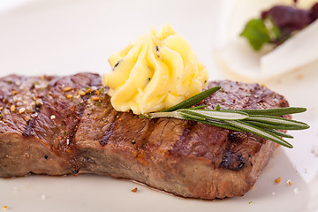 Image showing Grilled beef steak topped with butter and rosemary