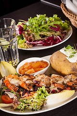 Image showing Grilled prawns with endive salad and jacket potato