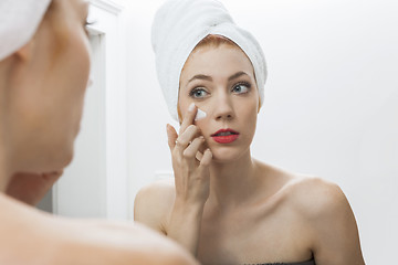 Image showing Woman After Shower Applying Cream on her Face