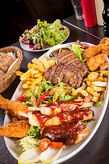 Image showing Platter of mixed meats, salad and French fries