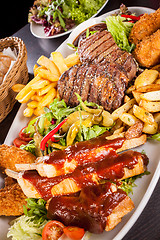 Image showing Platter of mixed meats, salad and French fries