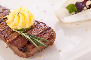 Image showing Grilled beef steak topped with butter and rosemary