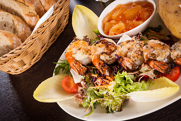 Image showing Grilled prawns with endive salad and jacket potato