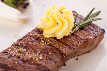 Image showing Grilled beef steak topped with butter and rosemary