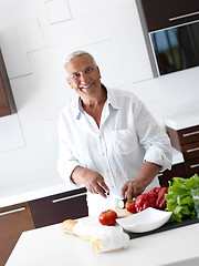 Image showing man cooking at home preparing salad in kitchen