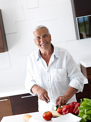 Image showing man cooking at home preparing salad in kitchen