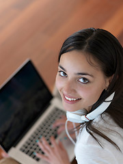 Image showing relaxed young woman at home working on laptop computer