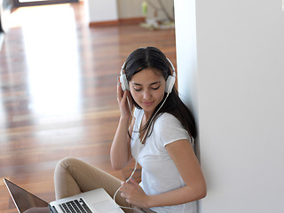 Image showing relaxed young woman at home working on laptop computer