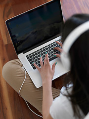 Image showing relaxed young woman at home working on laptop computer