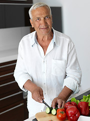 Image showing man cooking at home preparing salad in kitchen