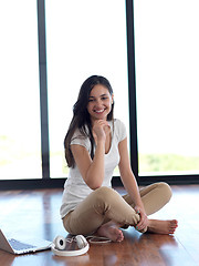 Image showing relaxed young woman at home working on laptop computer