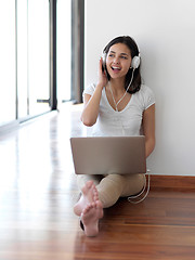 Image showing relaxed young woman at home working on laptop computer