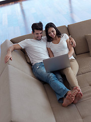 Image showing relaxed young couple working on laptop computer at home