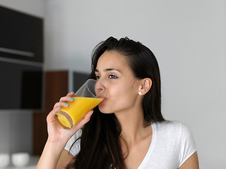 Image showing woman drinking juice in her kitchen