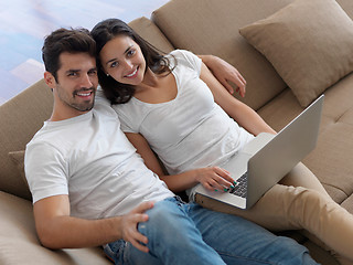 Image showing relaxed young couple working on laptop computer at home