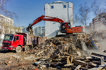 Image showing Excavator loads garbage from demolished house