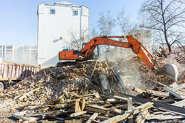 Image showing Excavator loads garbage from demolished house