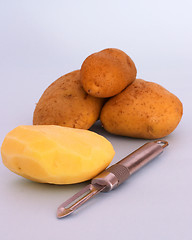 Image showing Potatoes and peeler