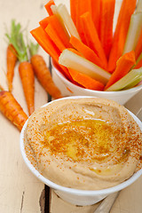 Image showing fresh hummus dip with raw carrot and celery 