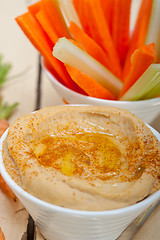 Image showing fresh hummus dip with raw carrot and celery 