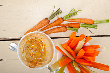 Image showing fresh hummus dip with raw carrot and celery 