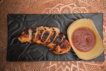 Image showing the cut chicken fillet baked in spices and tomato sauce