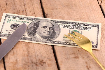 Image showing american money on wooden plate with knife and fok