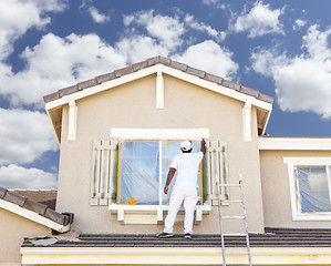 Image showing House Painter Painting the Trim And Shutters of Home