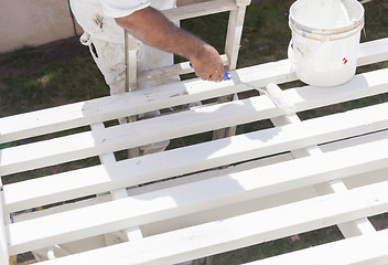 Image showing Painter Rolling White Paint Onto Top of Patio Cover