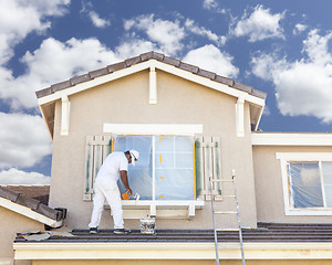 Image showing House Painter Painting the Trim And Shutters of Home