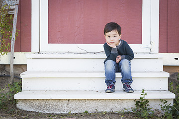 Image showing Cute Mixed Race Boy Sitting on the Steps of a Barn