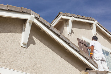 Image showing House Painter Painting the Trim And Shutters of Home