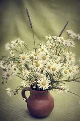 Image showing Bouquet of wild flowers in a clay pot, close-up  