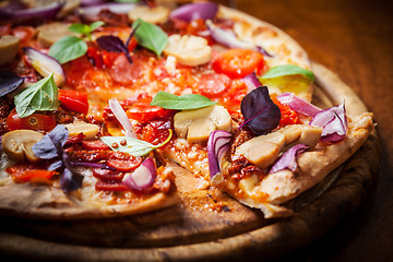 Image showing Homemade pizza with dried tomatoes and salami 