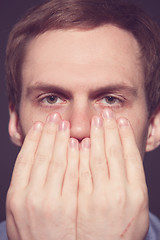 Image showing Speak no evil concept - Face of men covering his mouth. 