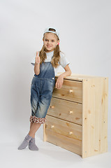 Image showing Girl in overalls collector of furniture based on the chest shows class