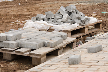 Image showing Elements of paving slabs lying on ground near sidewalk